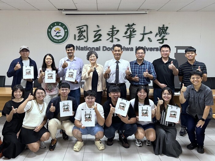 東華大學代表共同與校友合影留念，校友手持紀念品，紀錄這溫馨又難忘的時刻